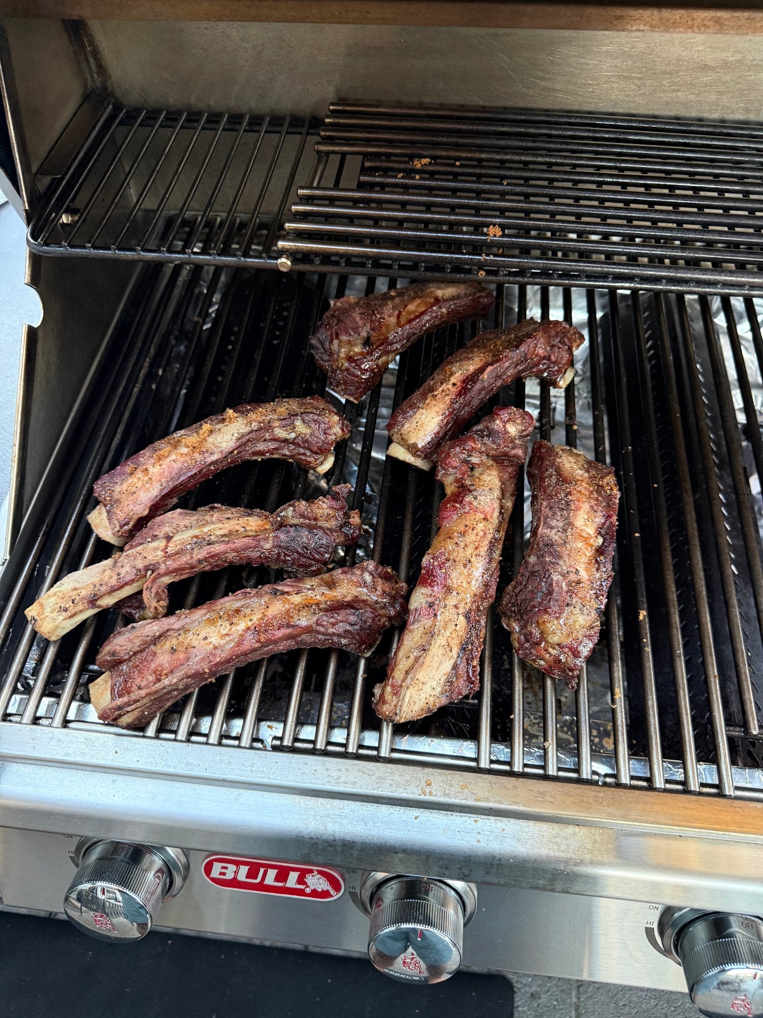 Beef back ribs smoking indirect over Hawaiian kiawe wood on a three-burner gas grill