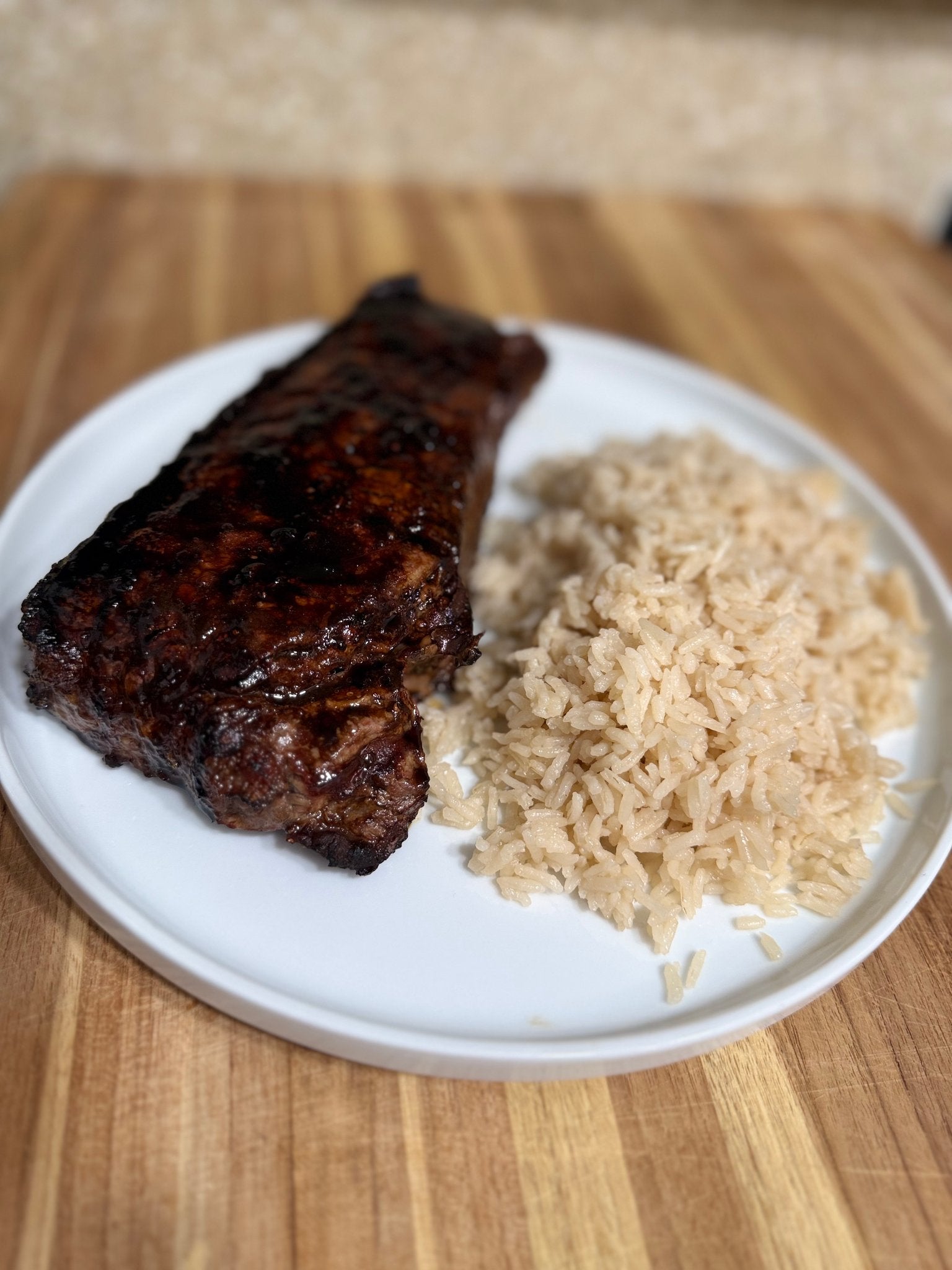 Island shoyu-guava glazed New York strip steak plated with coconut rice